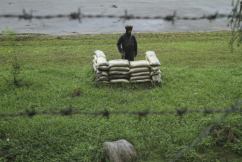 Indian army soldier stands guard close to the Line of Control, a ceasefire line dividing Kashmir between India and Pakistan, in Poonch